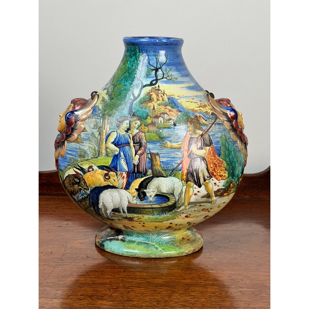 This hand-painted antique Italian Renaissance Revival maiolica vase (c. 1920-1940) features winged putti handles and a vibrant pastoral scene with shepherds, sheep, and goats—showcasing exquisite ceramic artistry and historic charm. Brand: Unknown.