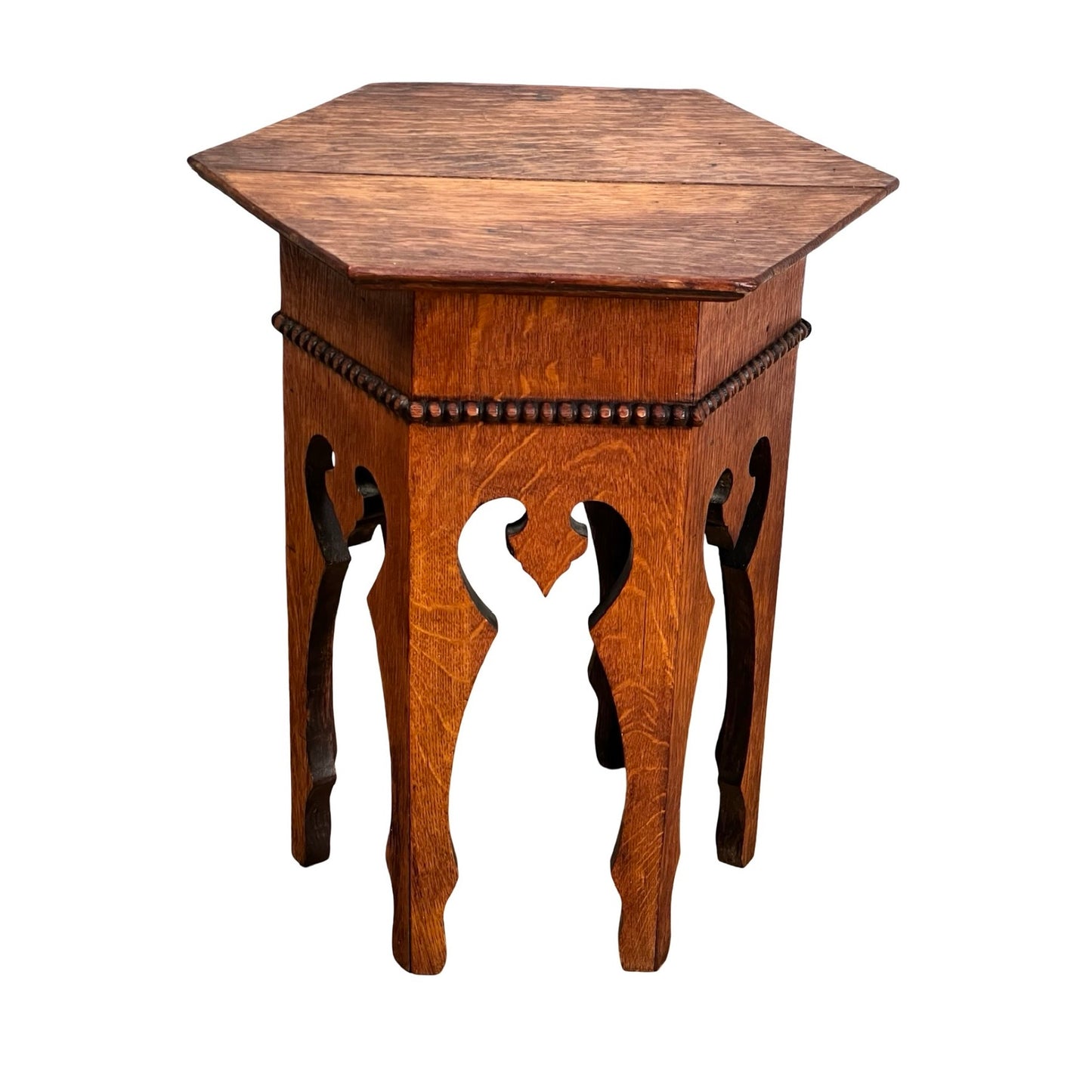 The Antique Arts & Crafts Small Oak Occasional Table c. 1910 features a carved hexagonal design with ornate legs and decorative bead trim, showcasing vintage Arts & Crafts style. Aged oak finish. Table shown isolated on white background.