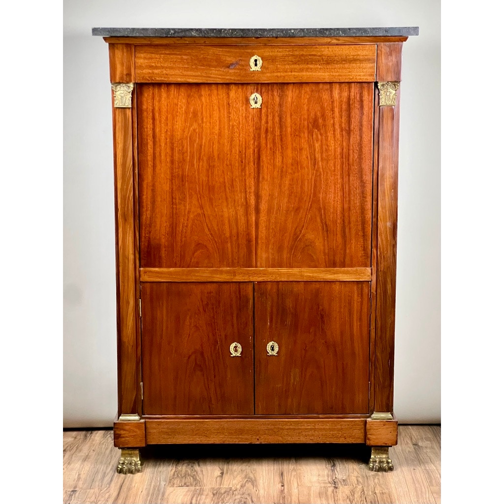 Antique French Empire Secrétaire Abattant with ormolu mounts, c. mid 19th century, features rich mahogany veneer, dark stone top, clawed feet, pull-down desk front, an upper drawer, and two lower doors with round brass handles.