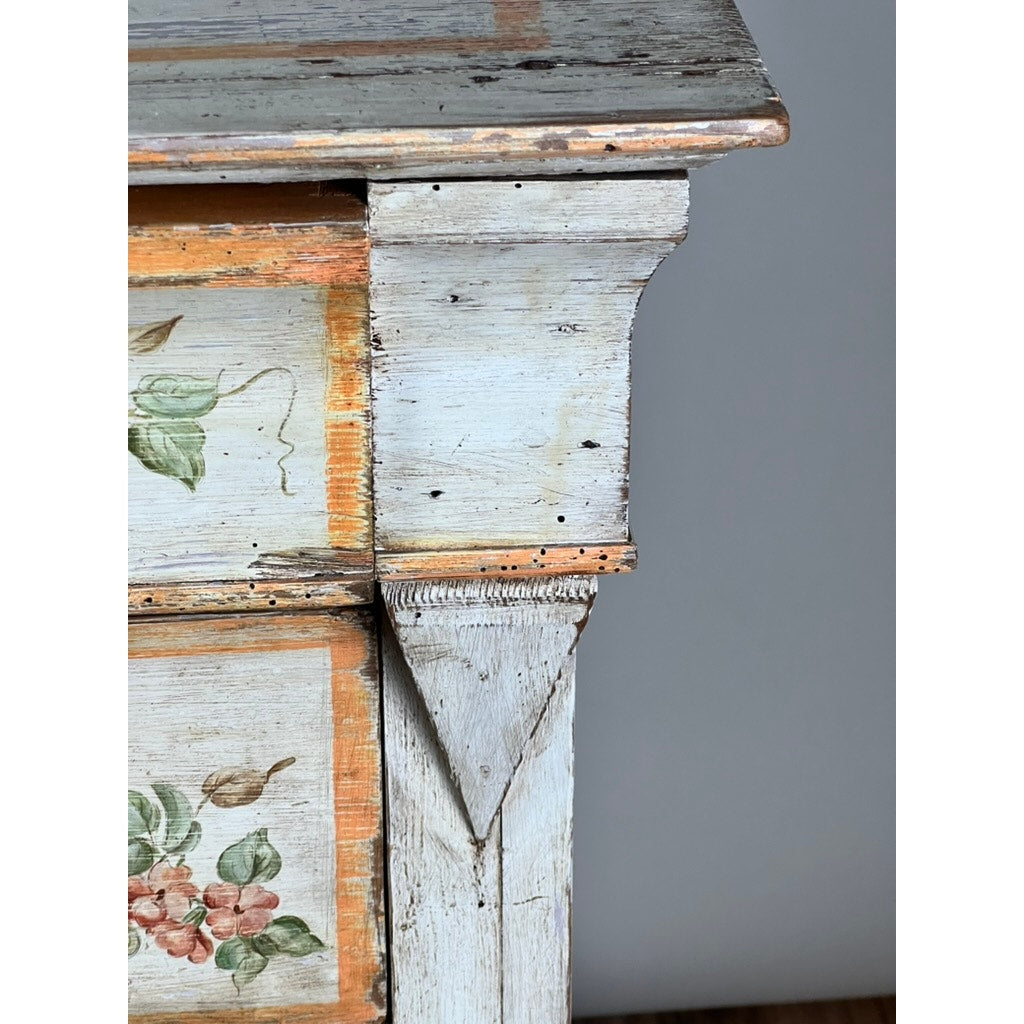 Close-up of an Antique Italian Paint Decorated Four Drawer Commode, early 19th century, featuring distressed pale blue paint, orange trim, floral accents, and aged wood for authentic provincial rustic charm. Brand unknown.