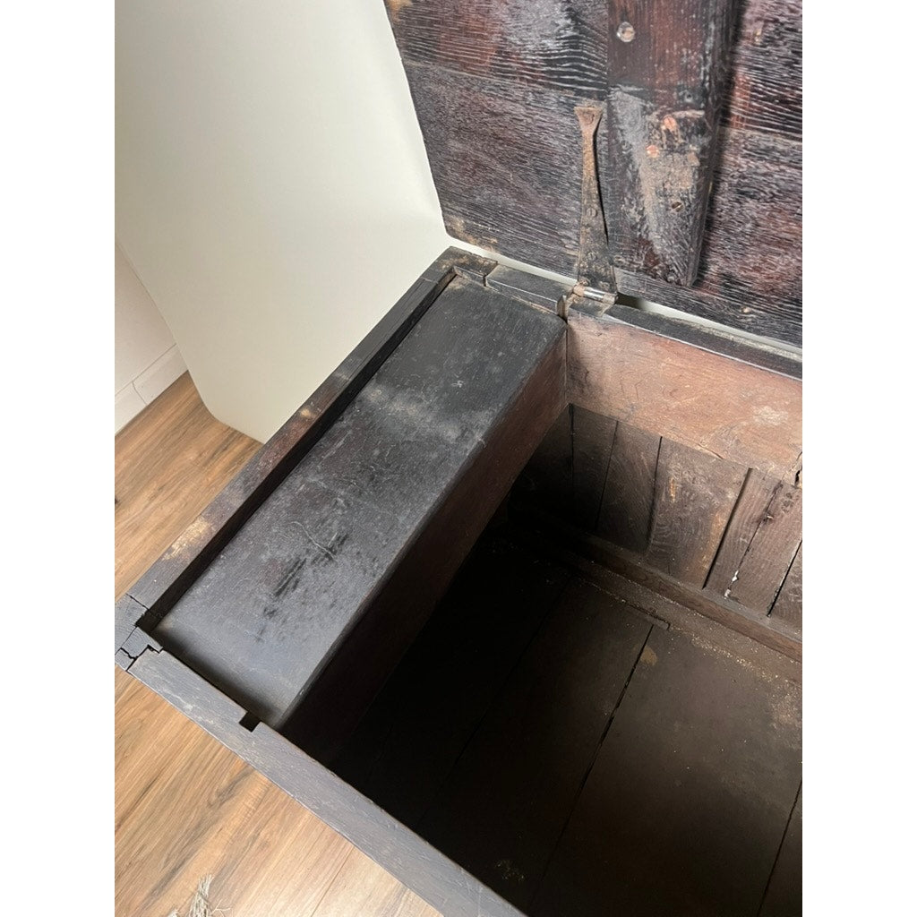 An Antique 18th Century Charles II Style Mule Chest, possibly Irish or Scottish, features worn dark wood, visible hinges, and a secret side compartment, all set atop a wooden floor.