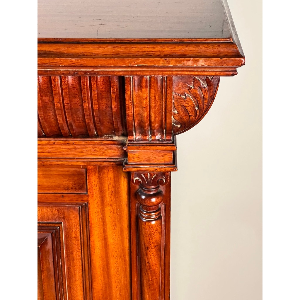 Close-up of an Antique English Jacobean Revival Mahogany Buffet c. 1915–1925, showcasing rich brown polished wood, decorative molding, fluted designs, and a leaf motif. Brand: None/Unknown.