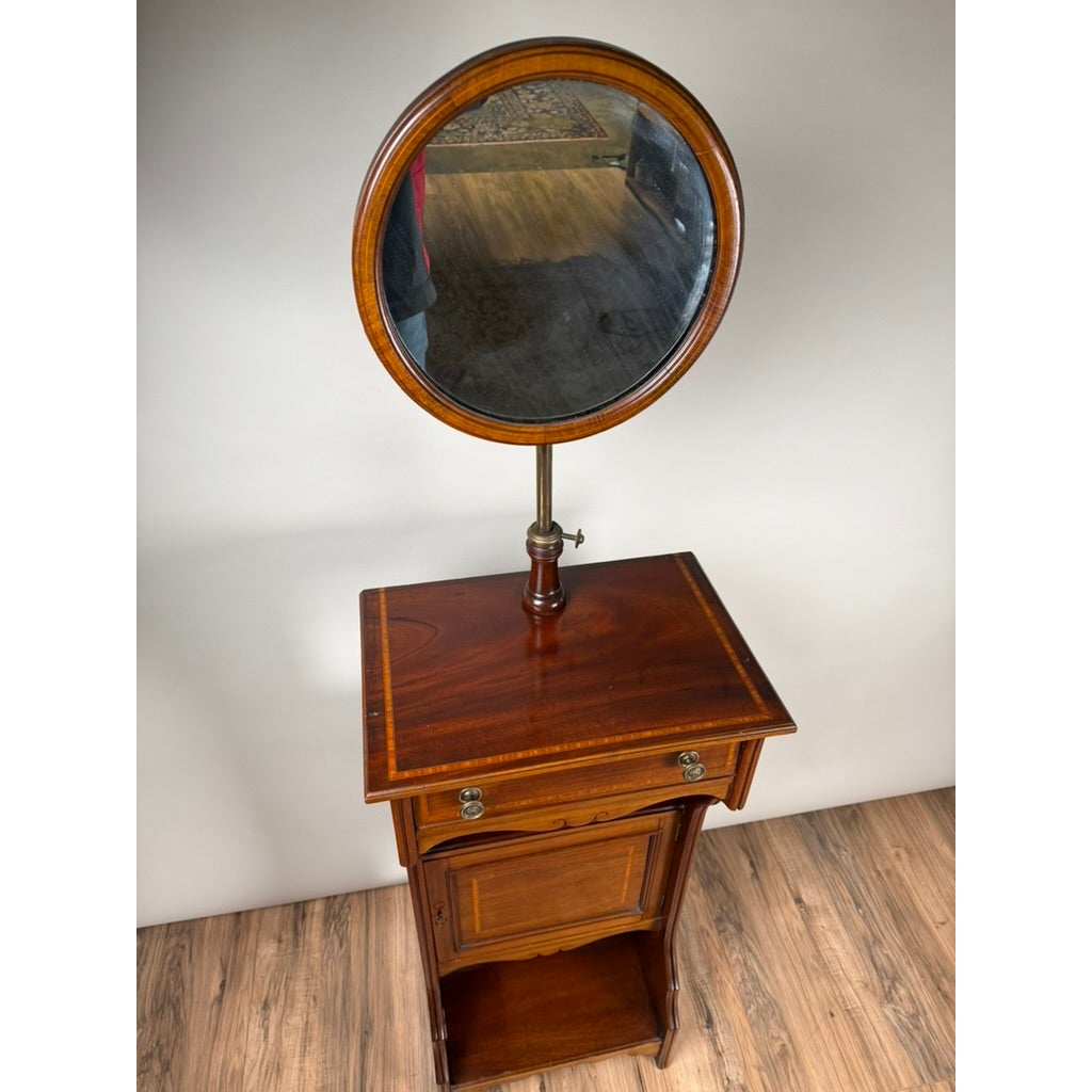 Antique English Mahogany Inlaid Shaving Stand with Adjustable Mirror, c. 1880–1900, featuring a tall mahogany frame with a drawer, cabinet, open shelf, and an adjustable circular mirror on a central post.
