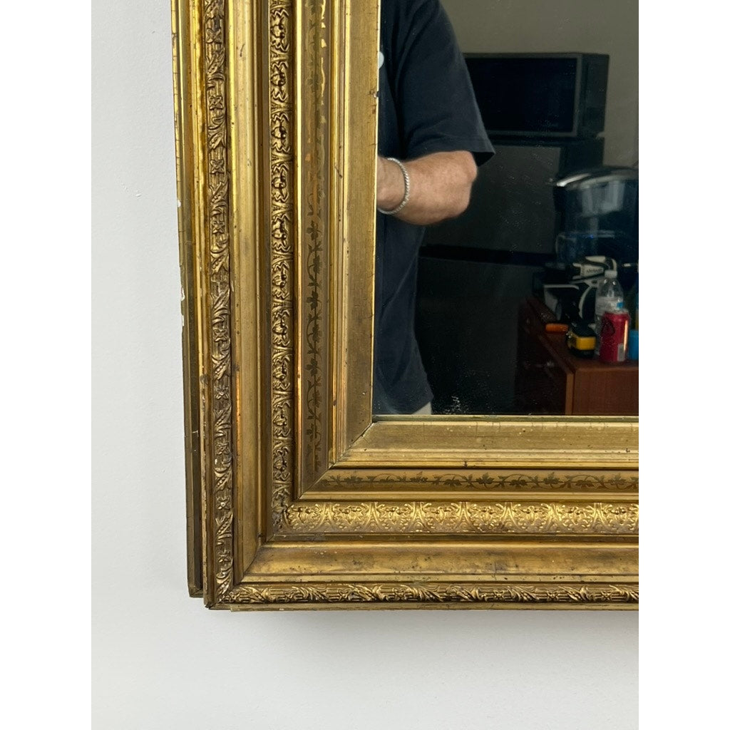 A close-up of a Fine Antique 19th Century Gilt Wood Mirror (39 x 34) captures a partial reflection of a person in a dark shirt, with shelves and a coffee maker visible in the background. Brand: Unknown.