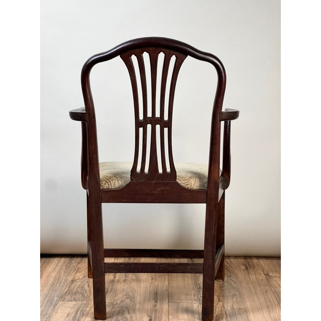 An Antique English George III Mahogany Hepplewhite Armchair (Early 19th Century) with curved armrests, ornate openwork backrest, and upholstered seat sits on a wooden floor against a plain light background.