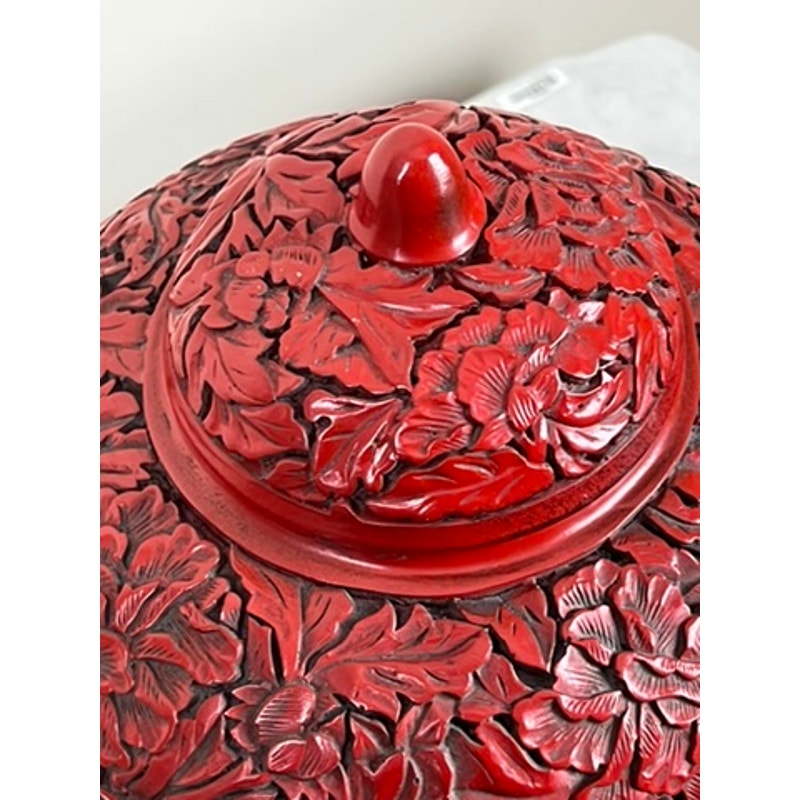 A close-up of the floral lid from an Antique Chinese Hand-Carved Cinnabar Lacquered Lidded Jar, probably Qianlong, showing detailed relief carvings of flowers and leaves. Brand: None or unknown.