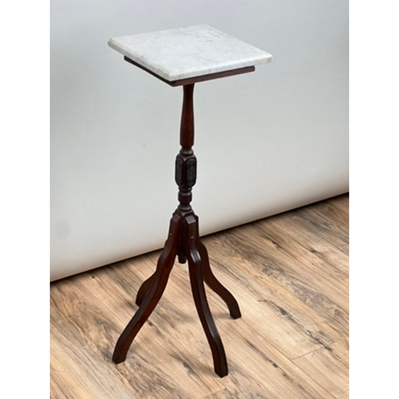 An Antique Victorian Marble Top Plant Stand from the late 19th century, featuring a square white marble top and three curved legs, stands on a wood-patterned floor against a plain light background. Brand: Unknown.