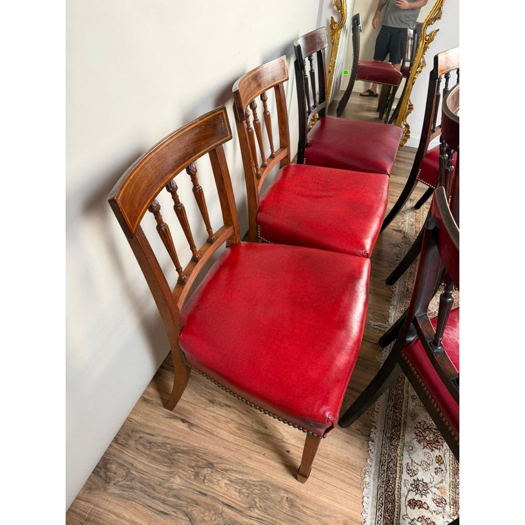 Six English George III mahogany neoclassical dining chairs by Pearl City Antiques, four of which are from the 18th century, are arranged in a row against a wall on a wooden floor. A mirror reflects part of the set, and a rug is partially visible in the lower right corner.