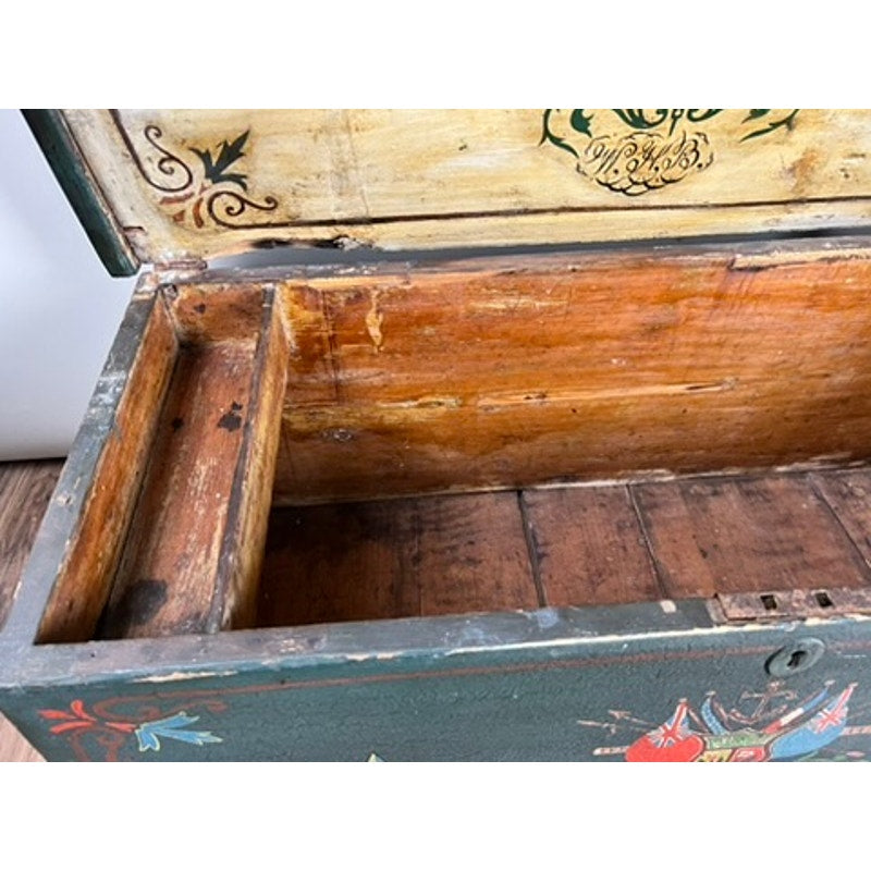 The Antique Paint Decorated English Sea Chest c. Late 19th Century features a painted exterior with floral designs and an open interior, displaying a simple, shallow compartment in the lid and worn wood with visible grain. Brand: Unknown.