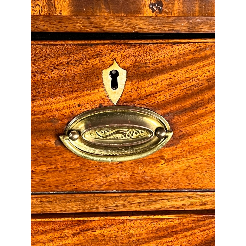 Close-up of a brass drawer pull and keyhole on an Antique George III Two Over Four Chest with French Feet c. Early 19th Century, showing the polished mahogany finish and visible wood grain.