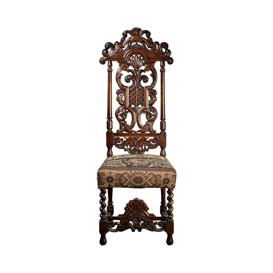 Antique Carolean Revival Side Chair (late 19th century) with intricate carved tall backrest and legs, plus a patterned upholstered seat in brown, green, and red. Brand: Unknown. Shown against a plain white background.