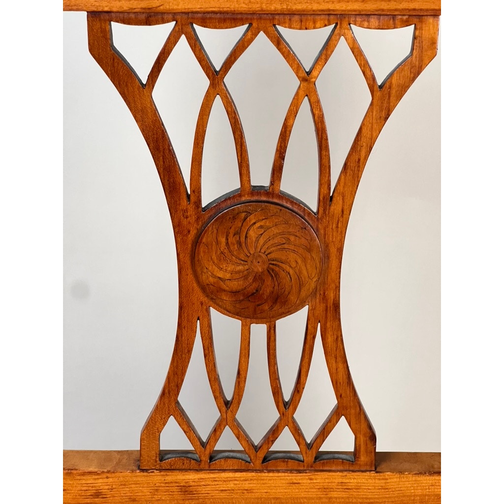 Close-up of an Antique German Biedermeier Style Cherry Side Chair (early 20th century) with intricately carved intersecting curves and a central floral motif, crafted in cherry veneer, set against a plain light background.