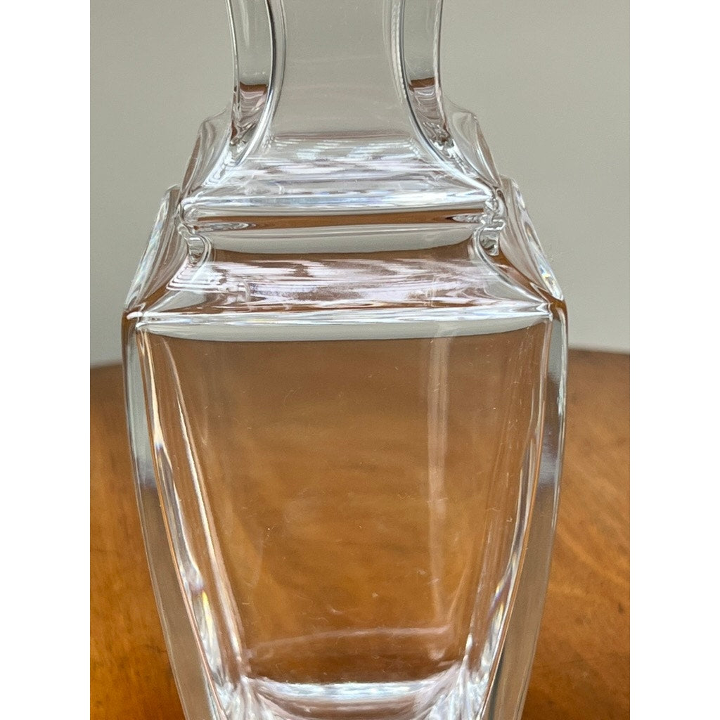 A close-up of the Vintage Baccarat Crystal Pearl Vase by Baccarat, featuring clear crystal with a square base, inspired by elegant French design, set on a wooden surface against a plain light background.