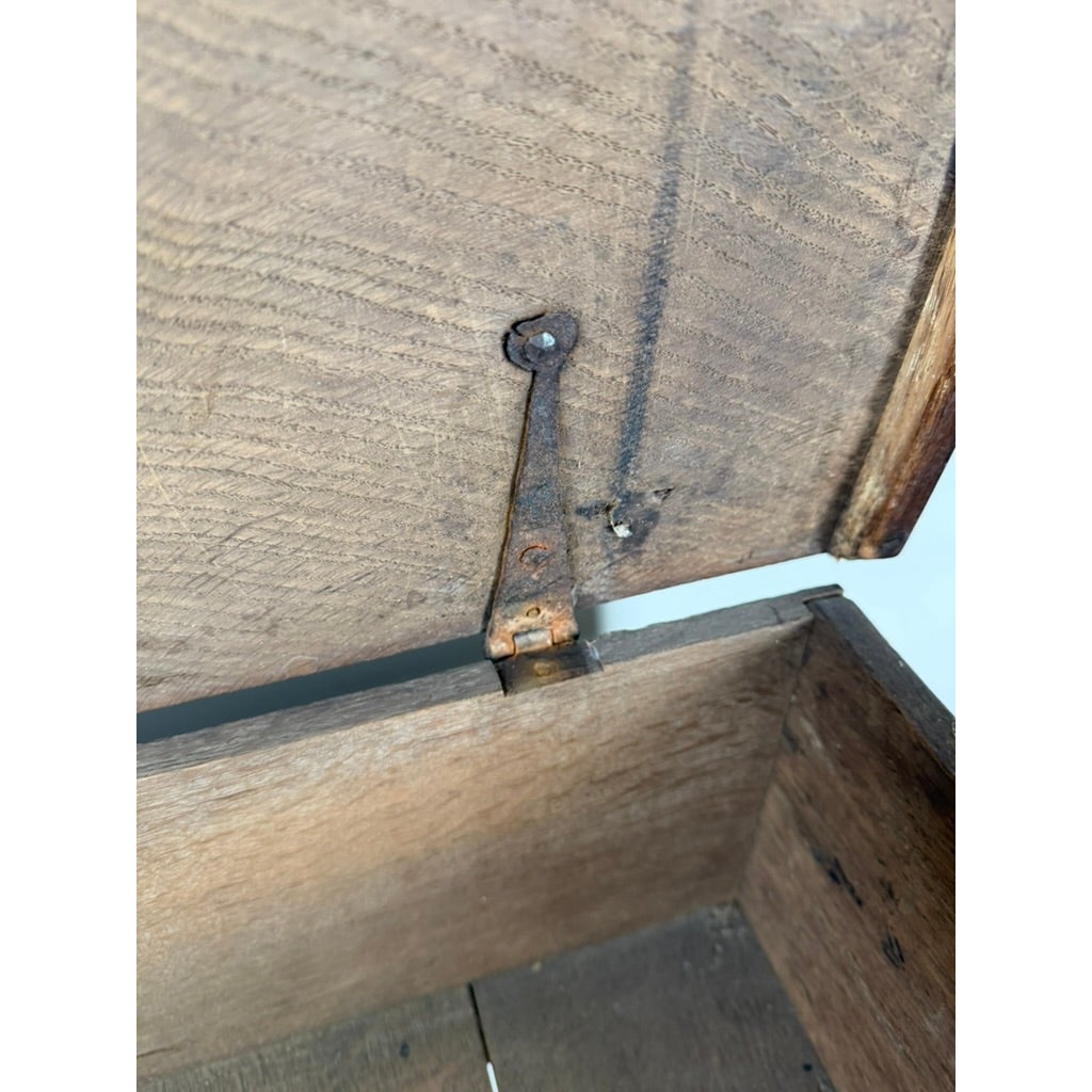 A view into an open English Jacobean Carved Oak Bible Box on Later Stand showing a rusted metal hinge attached to the lid.