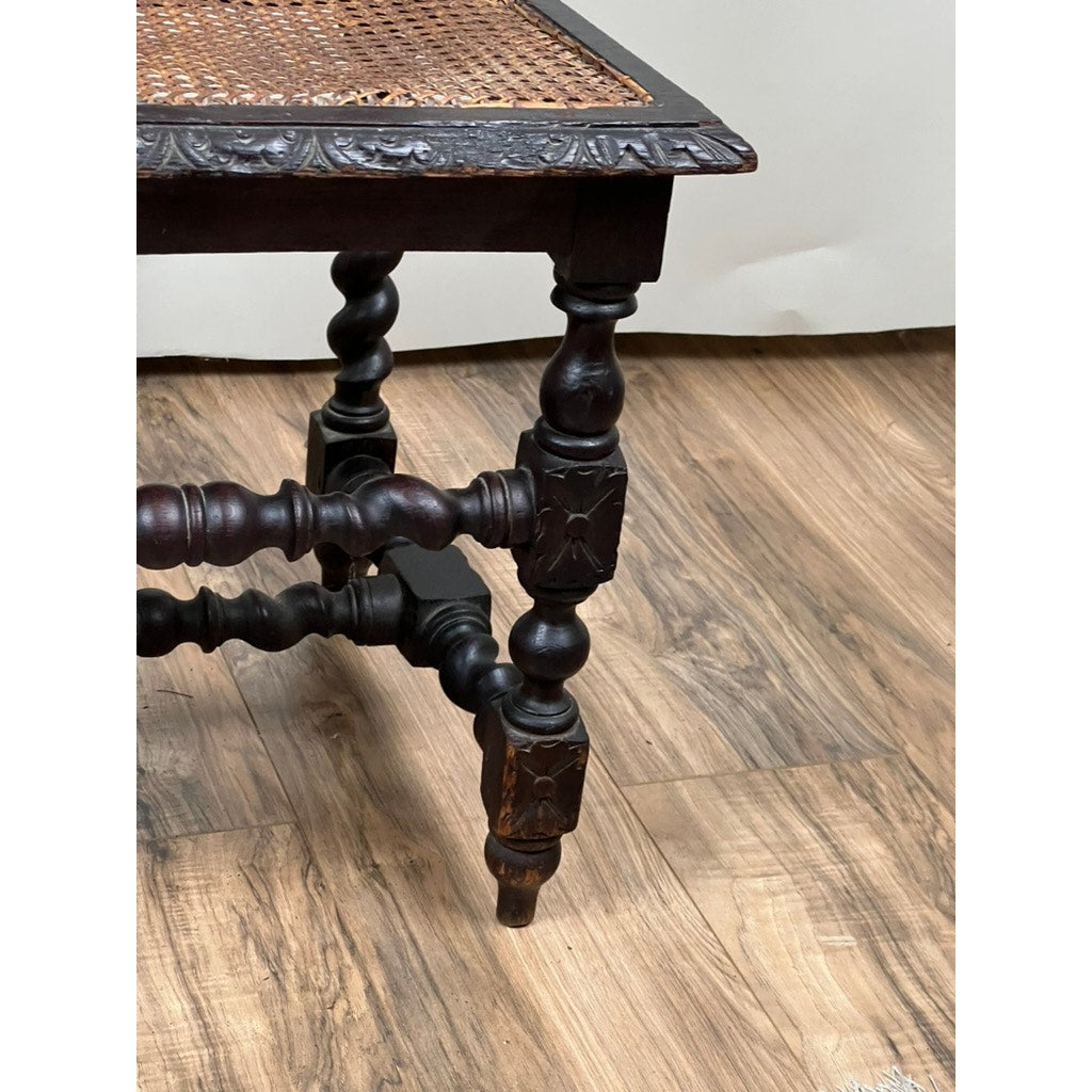 A close-up of a Pair Antique French Walnut Hunting Chairs c. Late 19th Century, featuring ornate twisted legs and woven cane seats, set on a wooden floor against a plain light-colored wall. Brand: Unknown.