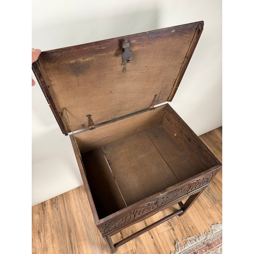 An open English Jacobean Carved Oak Bible Box on Later Stand, c. Late 17th Century, featuring a hinged lid and wooden base to reveal an empty interior.