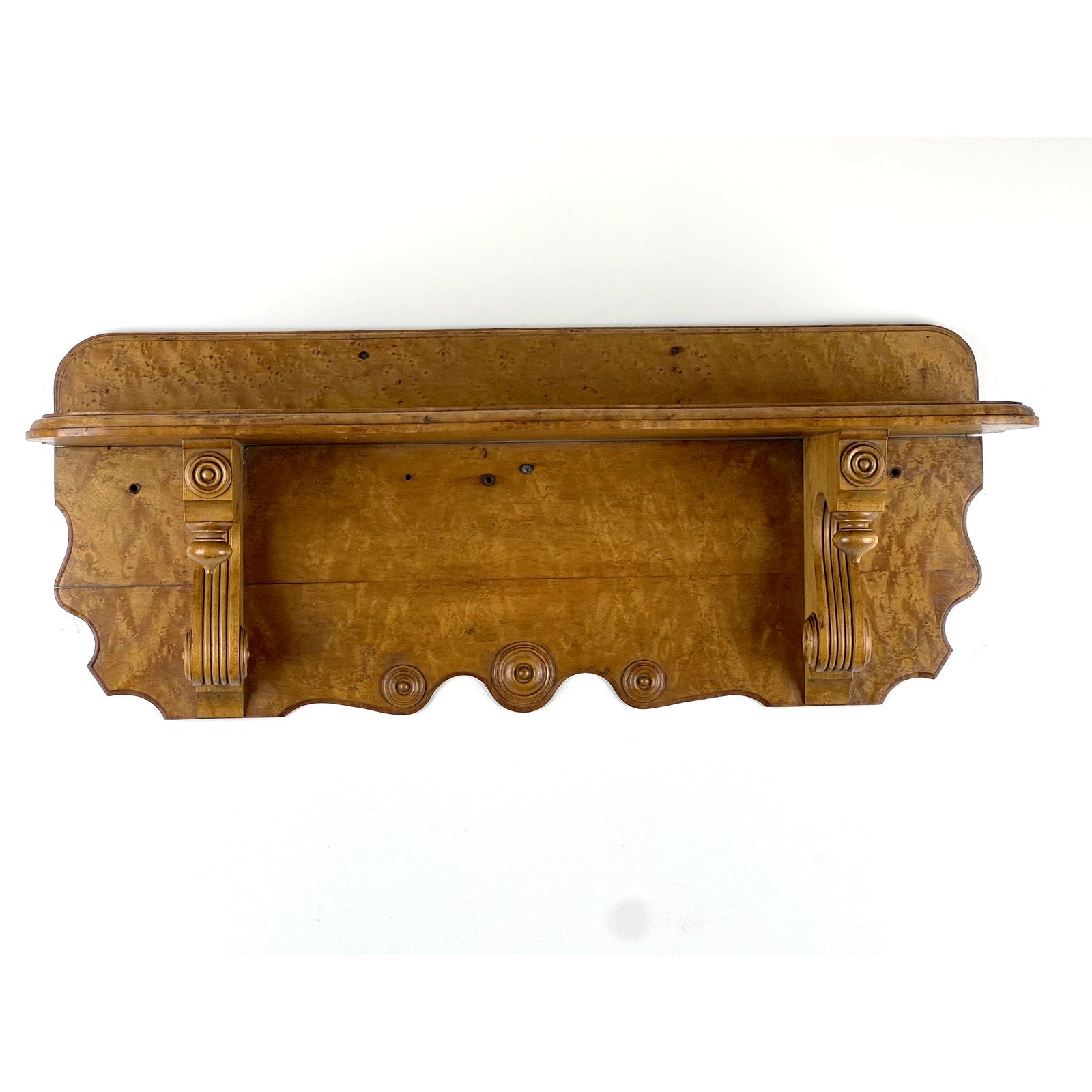 An Antique Victorian Birdseye Maple Wall Shelf from the late 19th century, featuring ornate carved brackets and scrollwork, is shown from the front against a white background. Brand: None/Unknown.