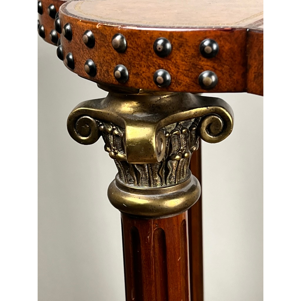 Close-up of a Vintage Maitland-Smith Leather-Clad Occasional Table leg by Maitland Smith, featuring a decorative brass capital with classical scrollwork and round brass nailhead trim along the edge for added elegance.