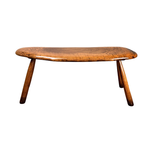 A vintage handmade oak Wabi Sabi bench, signed by Neil Panyik, features a rustic three-legged design with a curved smooth seat and angled legs, shown against a white background. Brand is unknown.