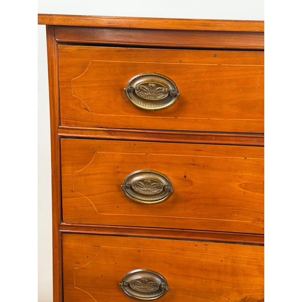 A Pennsylvania Federal Cherry Four-Drawer Chest with Satinwood String Inlay, featuring decorative string inlay and oval brass pulls.
