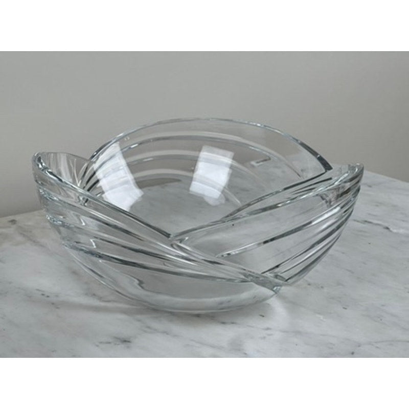 The Rogaska Samba Wave 10" Lead Crystal Bowl features an angular, geometric design, displayed on a white marble surface against a light gray background—showcasing the elegance of Rogaska’s European luxury crystal.