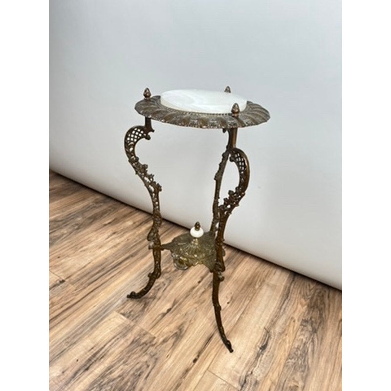 An Antique Victorian Bronze and Onyx Stand, circa late 19th century, features ornate decorative legs and a round onyx top, displayed on a wooden floor against a plain white wall. Brand: Unknown.