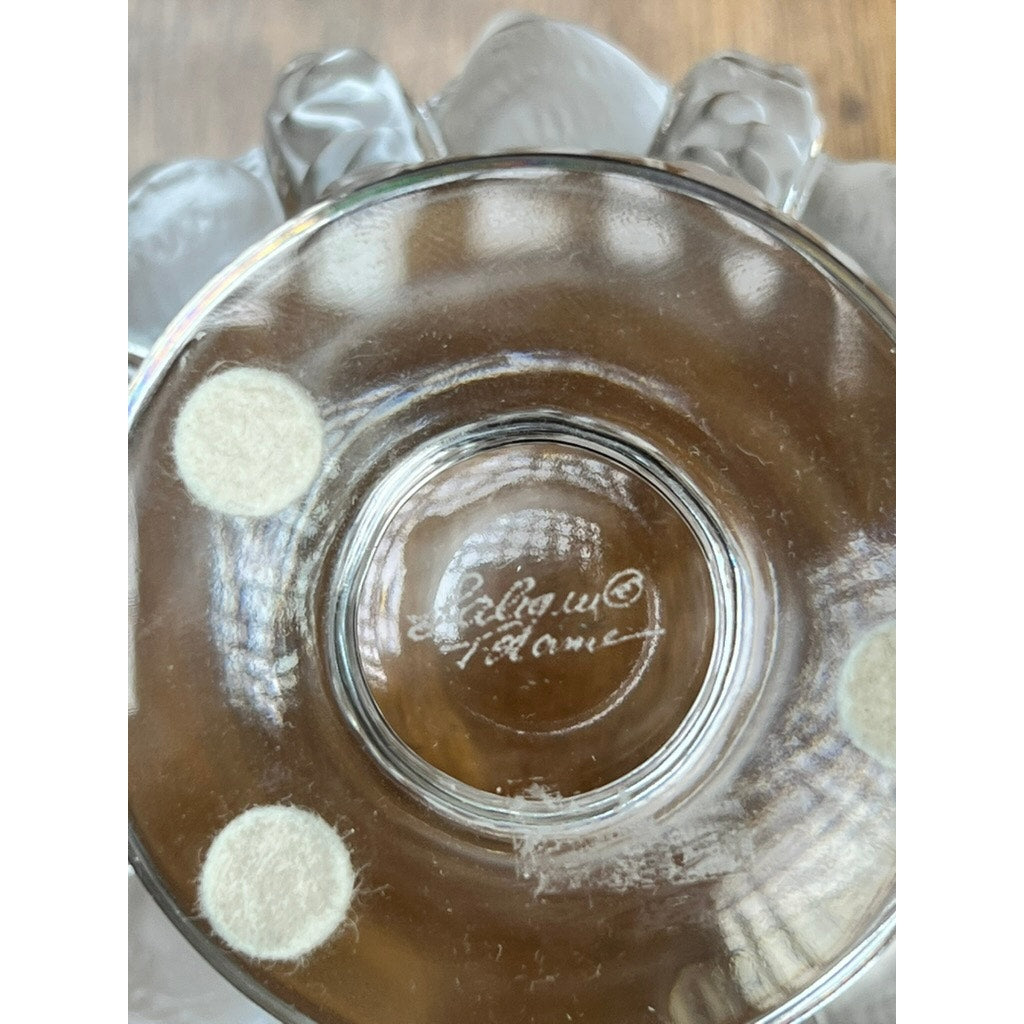 Close-up of the base of a Vintage Lalique Dampierre Sparrow Footed Vase, showing three circular felt pads and an etched “Lalique France” signature, set against a wooden background.