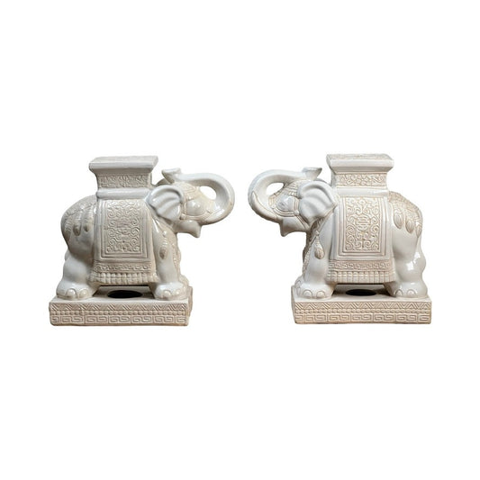 This Vintage Pair of White on White Glazed Hollywood Regency Style Elephant Garden Seats features ornate saddle-like decorations, flat tops, and rectangular bases with embossed patterns—an elegant accent for any space.