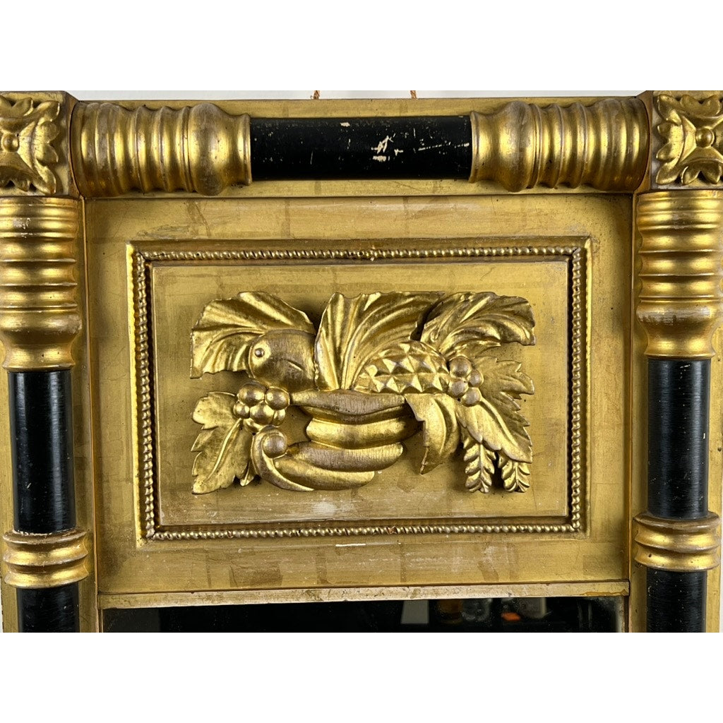 A close-up of an Antique Federal Period Giltwood Mirror, c. 1830, featuring ornate rosette corners, cornucopia motifs, fluted gold columns, and neoclassical carved details of birds among leaves and fruit. Brand: Unknown.