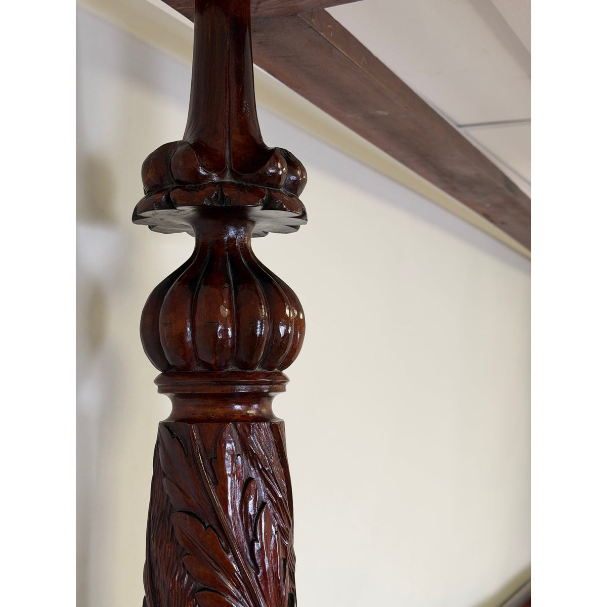 An American Classical Carved Mahogany Four-Poster Tester Bed post from the early 19th century, featuring an intricately carved base with leaf motifs and a rounded, fluted center finial.
