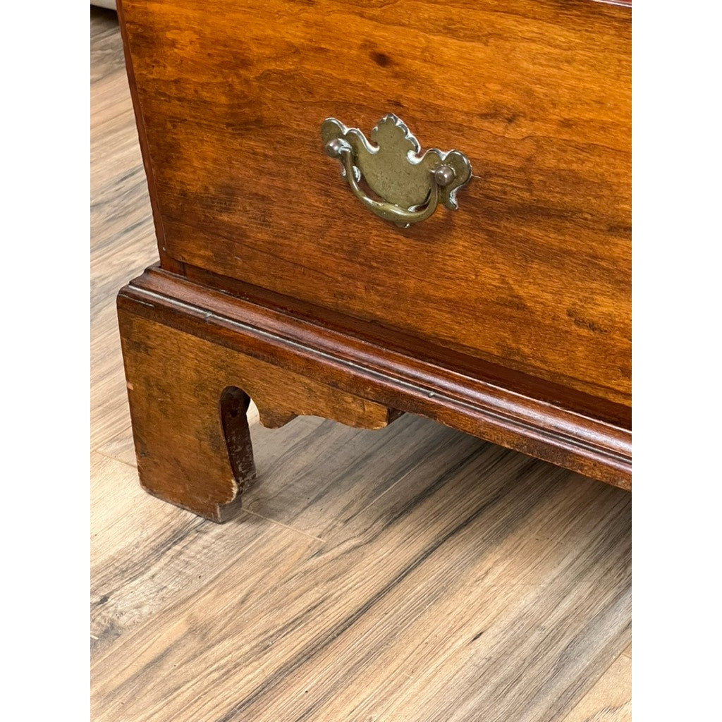 A close-up of the lower corner of an Antique George IV Butlers Secretary from the early 19th century, showing its brass handle, traditional joinery, and part of the leg on a wooden floor—exemplifying Regency English furniture.