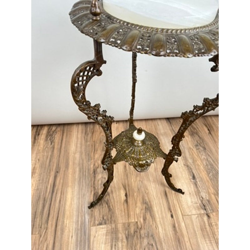 An Antique Victorian Bronze and Onyx Stand (late 19th century) with ornate metalwork, curved decorative legs, and a stone top stands on a wooden floor. Brand: None/Unknown.