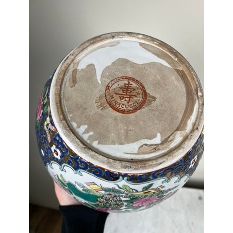 The underside of the Vintage Chinese Famille Rose Fish Bowl Signed Minicucci features a circular red stamp with Chinese characters. Cobalt blue gilt accents complement the vibrant floral patterns around the base.