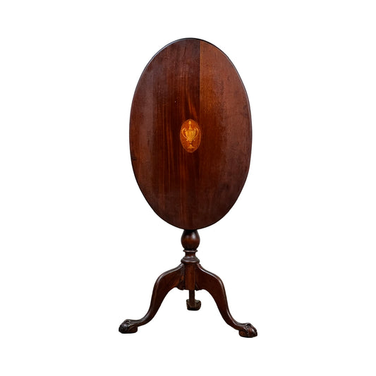 This Antique George III Tilt-top Tea Table c. Early 19th Century from Pearl City Antiques is an elegant oval mahogany table featuring a polished dark brown finish and a distinctive central satinwood inlay design. It stands on a single pedestal base with three curved legs ending in classic claw feet, and is photographed against a white background.