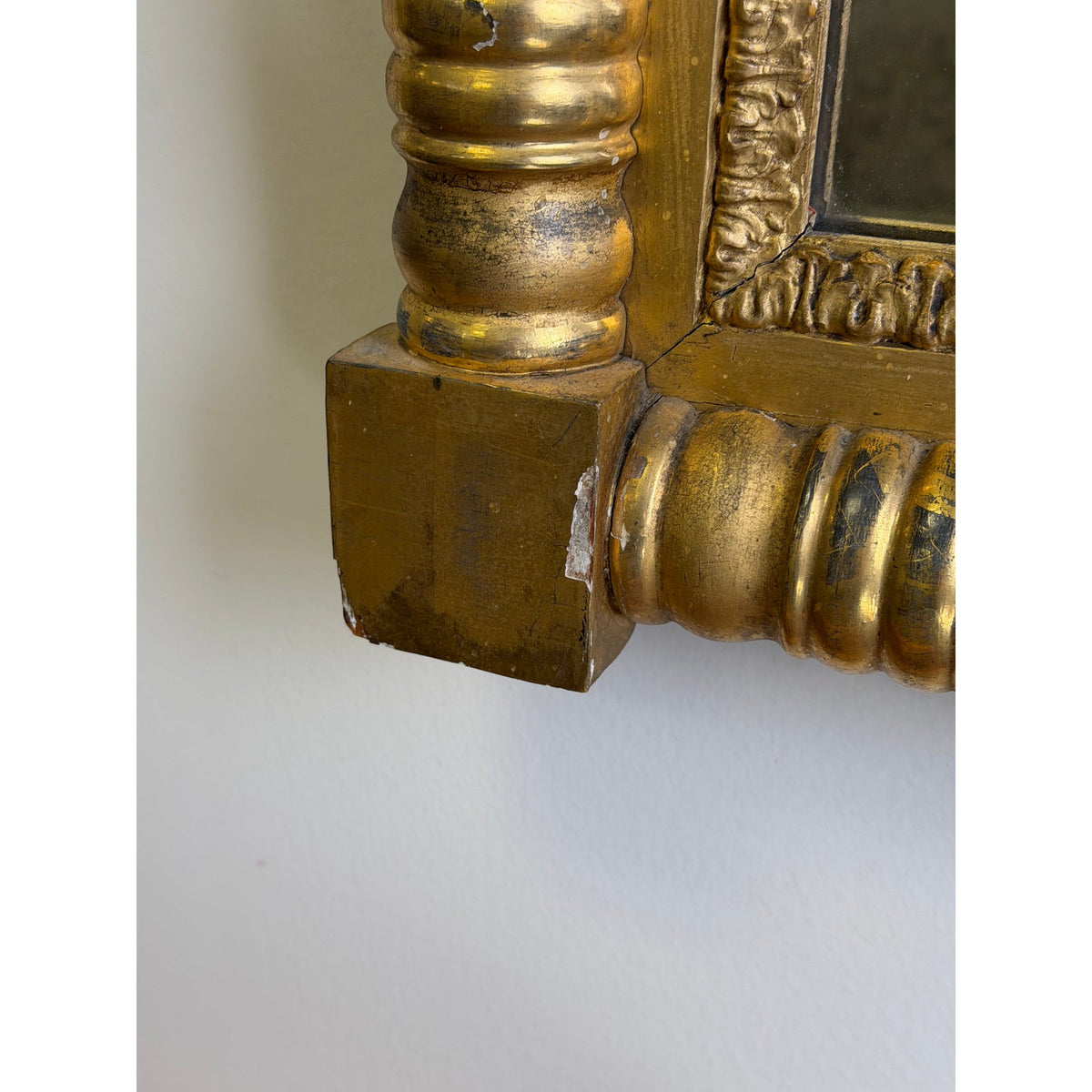 Close-up of the ornate, gold-finished wooden molding on the corner of an American Federal Giltwood Pier Mirror, Possibly Massachusetts or New York, circa 1815–1830, highlighting the carved decorative details.