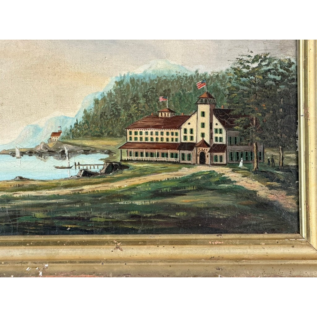 This 19th Century American Folk Art Adirondack or New England Resort Hotel Oil Painting from Pearl City Antiques beautifully depicts a grand lakeside resort with a stately two-tower building flying American flags. The scene is complete with a dock, boats along the shore, lush trees, and distant hills, capturing the tranquil charm of 19th century Americana.
