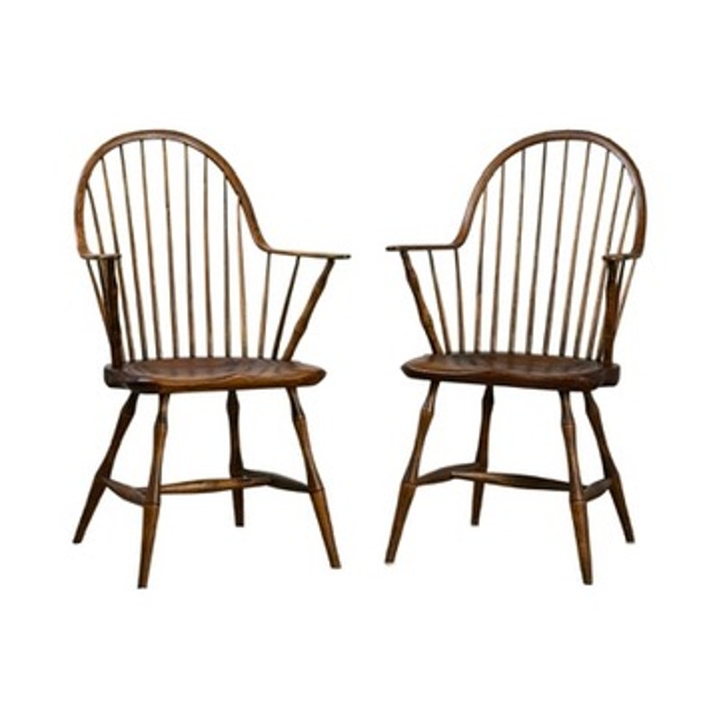 A pair of signed L.E. Partridge Connecticut bench-made continuous-arm Windsor chairs, circa 1960s, with high rounded spindle backs, armrests, and splayed legs are arranged facing slightly toward each other against a white background. These wooden chairs showcase classic early American design and fine craftsmanship inspired by traditional furniture-making techniques.