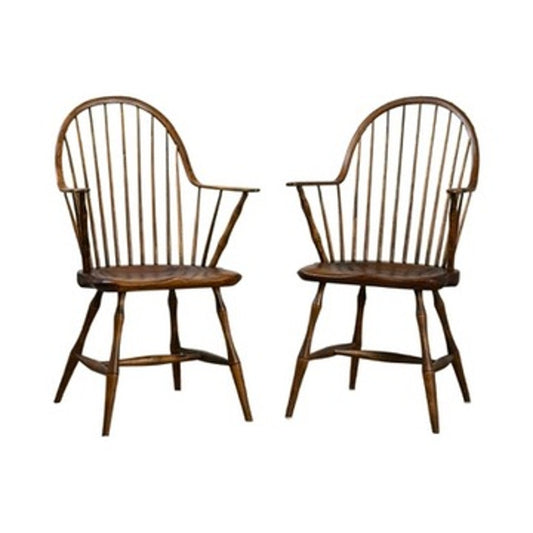 A pair of signed L.E. Partridge Connecticut bench-made continuous-arm Windsor chairs, circa 1960s, with high rounded spindle backs, armrests, and splayed legs are arranged facing slightly toward each other against a white background. These wooden chairs showcase classic early American design and fine craftsmanship inspired by traditional furniture-making techniques.
