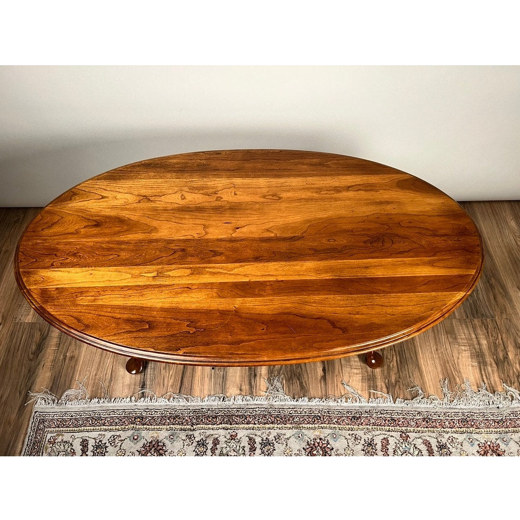 Vintage Solid Cherry Queen Anne Style Coffee Table, attributed to Pennsylvania House, displayed on a patterned fringed rug atop a wooden floor against a plain white wall.