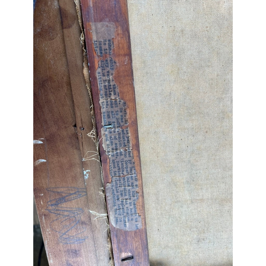 A close-up of the back of "Painting Oil on Canvas 'Two Ships Off the Beach' Signed Lower Left" reveals a torn, faded newspaper clipping and loose threads near the edge, offering a glimpse into the artwork’s vintage coastal history.