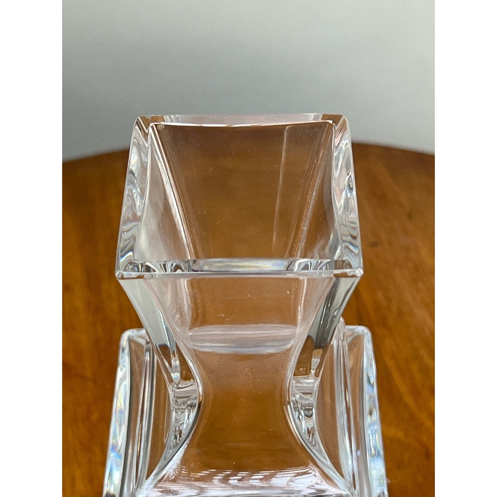 A close-up of the Vintage Baccarat Crystal Pearl Vase by Baccarat, featuring a clear, square design with smooth, angular edges, displayed on a wooden surface against a neutral background.