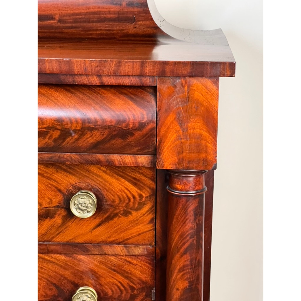 Close-up of an Antique American Empire Albany Four Drawer Chest c. 1840 in rich flame mahogany, featuring ornate wood grain, brass round drawer pulls, and decorative column sides—a fine example of classic 19th-century craftsmanship.
