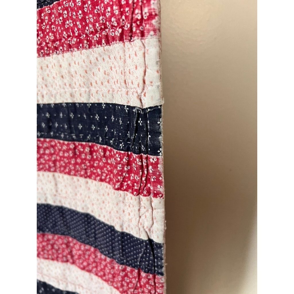 Close-up side view of a Matching Pair of Antique American Patriotic Hand Quilted Log Cabin Quilts (early 20th century), showing red, white, and blue striped and star patterns with stitching details against a light background. Brand: Unknown.