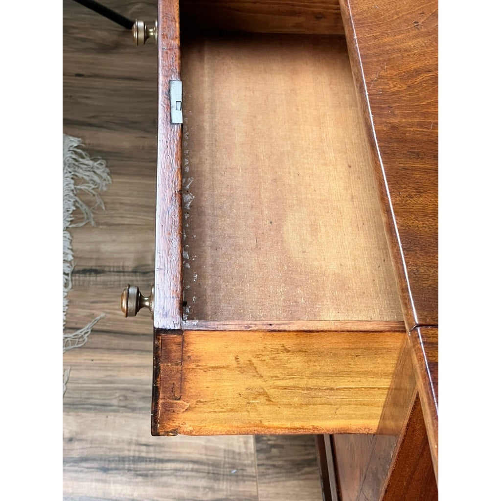 An open mahogany drawer with lion's head pulls is seen from above, revealing an empty interior. The drawer belongs to an Antique Federal Two Drawer Work Stand c. 1820 on a wood floor beside a fringed rug.