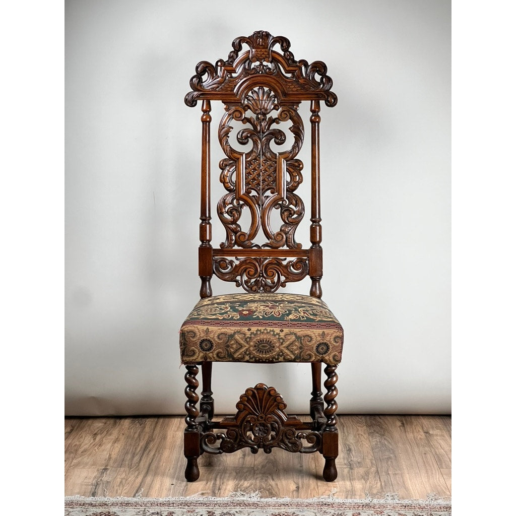 An Antique Carolean Revival Side Chair (late 19th c.), with intricate carvings, twisted legs, and patterned upholstery, stands on a wooden floor against a plain background. Brand: Unknown.