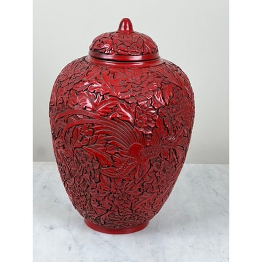 Antique Chinese Hand-Carved Cinnabar Lacquered Lidded Jar, probably from the Qianlong period, by Pearl City Antiques—this elegant red vase showcases intricate floral and bird relief patterns and is displayed on a light marble surface against a plain light-colored background.