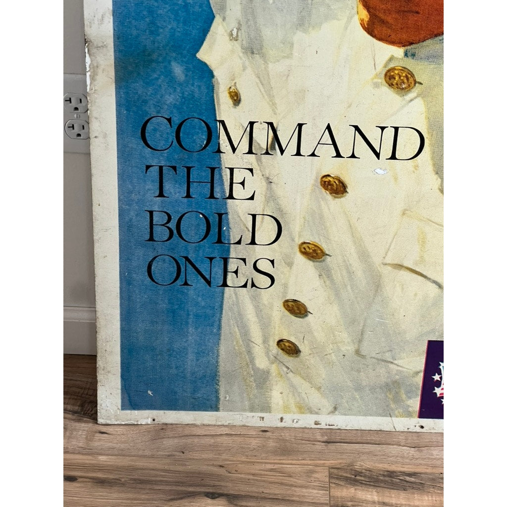 Close-up of an original Vietnam Era double-sided U.S. Navy recruiting tin sign by artist Lou Nolan, featuring the USS Saratoga. Part of a figure in white with gold buttons appears above a wooden floor; text reads "COMMAND THE BOLD ONES.