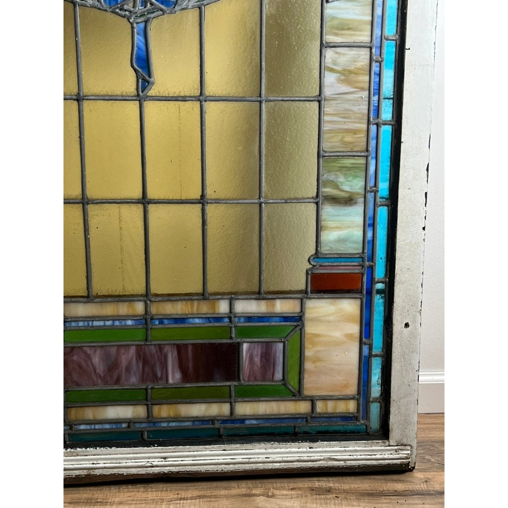 Antique stained glass with arched design and colorful geometric borders