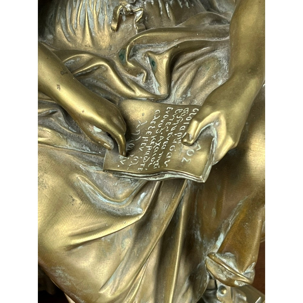 Close-up of the Antique Bronze Sculpture “Teacher and Pupil” by Louis Charles Janson, 1865, signed Ch. Janson, featuring a seated figure holding a tablet with ancient-style inscription and finely detailed clothing folds.