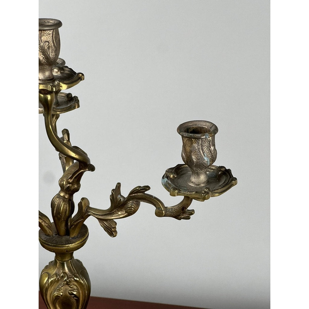 A close-up of a Vintage Brass Louis XV Style Four Light Candelabra with ornate scrollwork, brand unknown, displayed against a plain light gray background.
